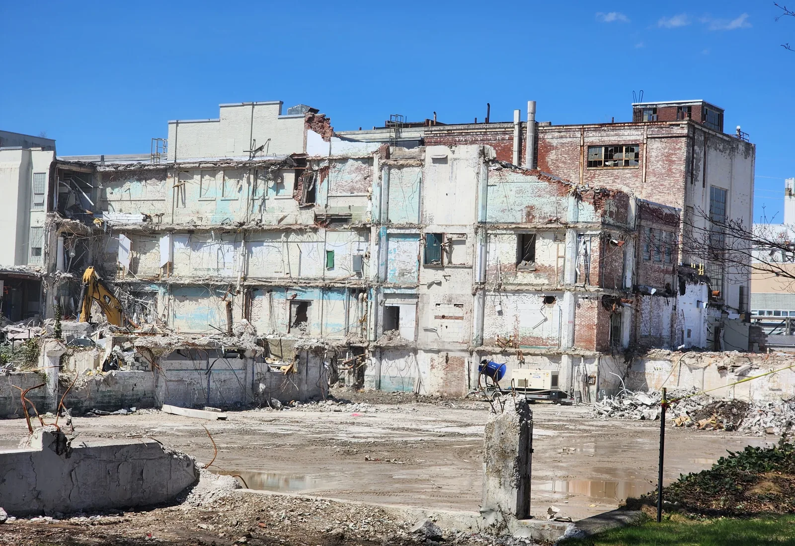 Cleared slab in front of a large brick building being taken down