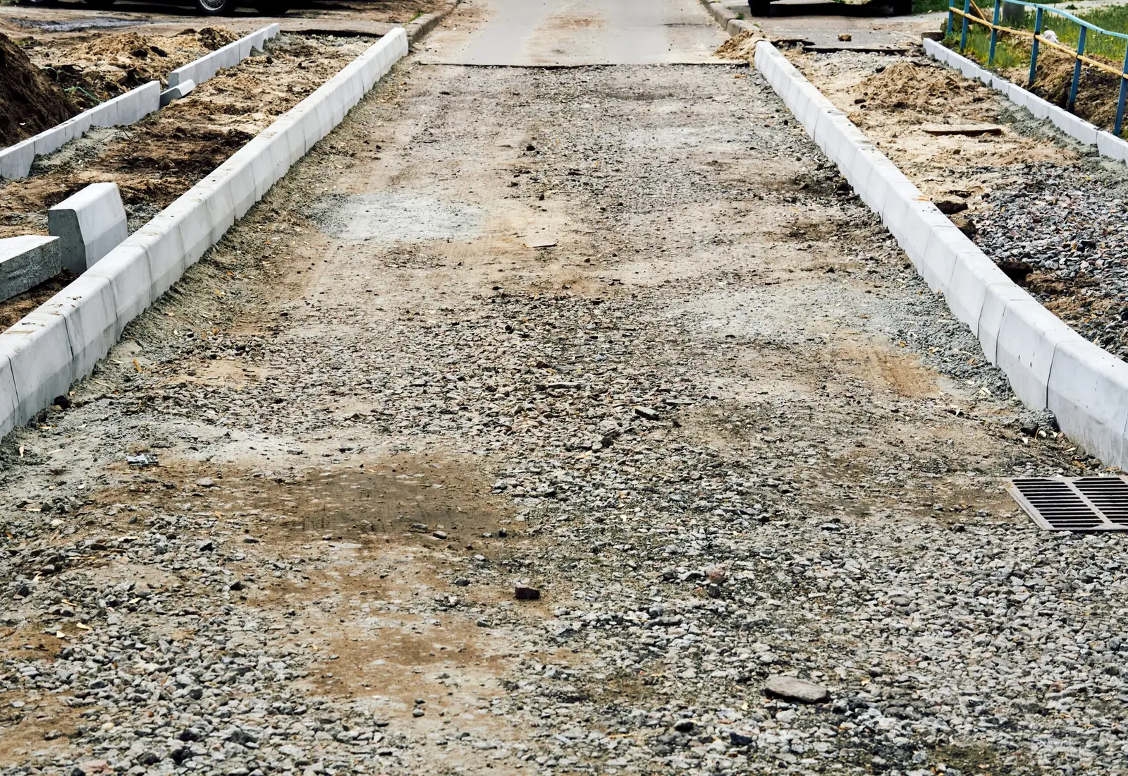 Crushed stone base spread between granite curbing on a new driveway